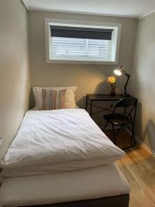 a bed in a bedroom with a table and a window at Apartment close to Aalesund center in Ålesund