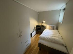 a small bedroom with a bed and a window at Apartment close to Aalesund center in Ålesund +7 photos