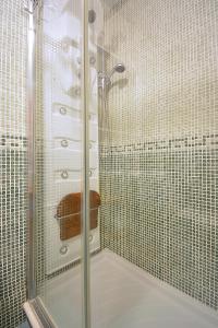 W łazience znajduje się prysznic ze szklanymi drzwiami. w obiekcie Apartamento con jardín en Playa de Corrubedo w mieście Ribeira