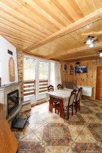 a dining room with a table and a fireplace at Cottage "Karpatske Shale" in Yaremche