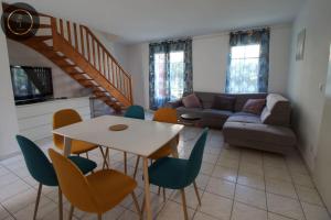 sala de estar con sofá, mesa y sillas en Maison 6 personnes à 4 KMS de DISNEY, en Magny-le-Hongre