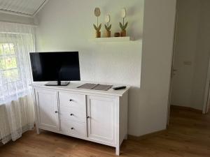 a white cabinet with a television on top of it at Idyllische Ferienwohnung in Wiefelstede in Wiefelstede