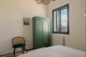 a green cabinet in a bedroom with a window at La Bella Vita Lecce in Lecce