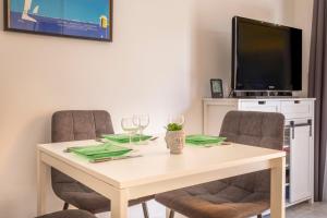 une table à manger avec deux chaises et une télévision dans l'établissement Nice studio near the sea in Bandol - Welkeys, à Bandol