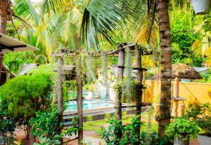 een tuin met een zwembad en een palmboom bij Mandavilla Airport Transit Hotel in Demanhandiya