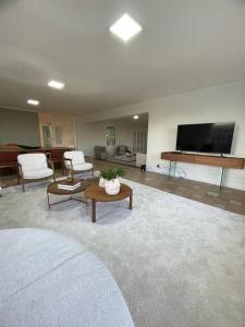 a living room with a couch and a tv at Casa Alto Padrao - Terras Sao Jose 1 (Campo Golfe) in Itu