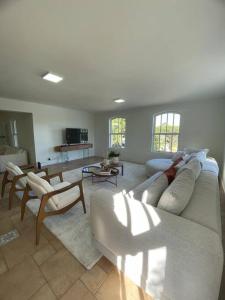 uma sala de estar com um sofá branco e cadeiras em Casa Alto Padrao - Terras Sao Jose 1 (Campo Golfe) em Itu