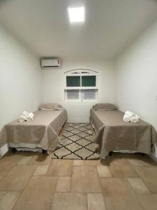 um quarto com duas camas e uma janela em Casa Alto Padrao - Terras Sao Jose 1 (Campo Golfe) em Itu