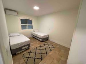 um pequeno quarto com 2 camas e uma janela em Casa Alto Padrao - Terras Sao Jose 1 (Campo Golfe) em Itu