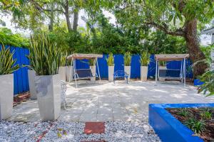 een patio met stoelen en een blauw hek bij Casa Wynwood Miami in Miami