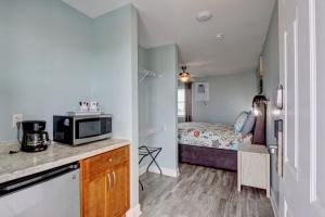 een kleine keuken met een magnetron en een slaapkamer bij Unit 08 at Tiffany's in Surf City