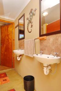 a bathroom with two sinks and a mirror at Oasis Country Lodge in Klawer