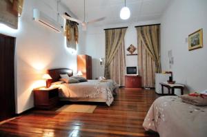 a bedroom with two beds and a wooden floor at Oasis Country Lodge in Klawer