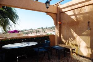 un patio avec une table, des chaises et une fenêtre dans l'établissement Argan Oasis Studio, Poolside Retreat near Taghazout, à Ikouzza
