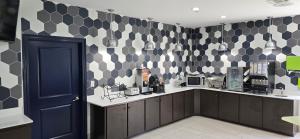 a kitchen with black and white tiles on the wall at La Quinta by Wyndham Gonzales LA in Gonzales
