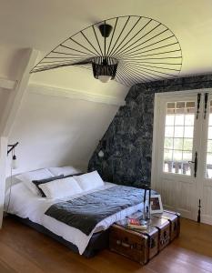 ein Schlafzimmer mit einem großen Bett und einer großen Decke in der Unterkunft Maison de charme, près des plages du Débarquement in Bayeux