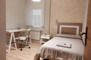 a bedroom with a bed and a desk and a desk at Piso familiar zona estación tren- bus-4 caminos in A Coruña