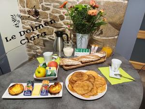 uma mesa com dois pratos de comida para o pequeno almoço em Le Loft du Dolmen Clara, entre terre et mer em Plounévez-Lochrist