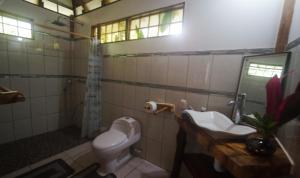 a bathroom with a toilet and a sink at casa de los amigos caribena in Cahuita