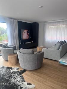 sala de estar con 2 sofás y TV de pantalla plana en All the comforts at the beach, en Waitarere