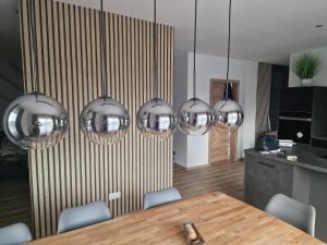 een eetkamer met een tafel en zes zilveren lampen bij Ferienwohnung Engel in Grebenstein