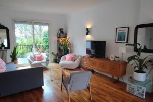 ein Wohnzimmer mit einem Sofa und einem TV in der Unterkunft Belle maison nantaise avec piscine in Nantes