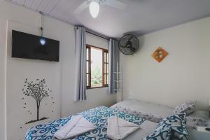 a bedroom with a bed and a tv on the wall at Hostel Cabo Frio in Cabo Frio
