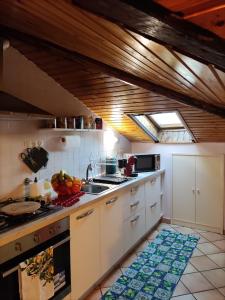 uma cozinha com um lavatório e um fogão forno superior em Le finestrine em Catânia