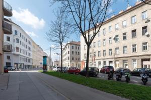 eine Stadtstraße mit parkenden Autos und Gebäuden in der Unterkunft Zentral und ruhig bei Schönbrunn in Wien