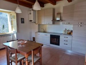 eine Küche mit einem Holztisch sowie einem Tisch und Stühlen in der Unterkunft La vecchia canonica in Fivizzano