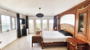 威廉斯塔德的住宿－Reverie，一间卧室配有一张木床和一把椅子
