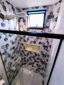 uma casa de banho com um chuveiro, um lavatório e uma janela. em Studio luxuoso a 700 metros da praia. Vila Velha ES em Vila Velha