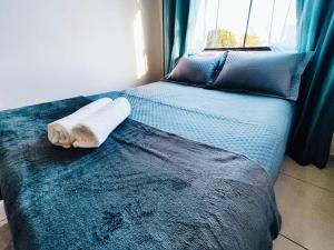 a bed with a towel on it with a window at Studio luxuoso a 700 metros da praia. Vila Velha ES in Vila Velha