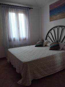星之塔的住宿－Appartamento a 50 metri dal mare，卧室配有一张带白色床单的大床和窗户。