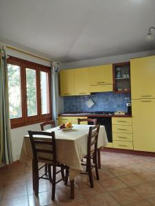 星之塔的住宿－Appartamento a 50 metri dal mare，厨房配有桌椅和黄色橱柜