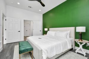 um quarto verde com uma cama branca e uma parede verde em NEW! Luxury Escape: 3BR Oasis em Houston