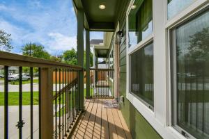 een veranda aan de voorzijde van een huis met een balkon bij NEW! Luxury Escape: 3BR Oasis in Houston