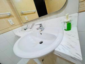 y baño con lavabo blanco y espejo. en AlRaef Luxury Apartments en Dubái
