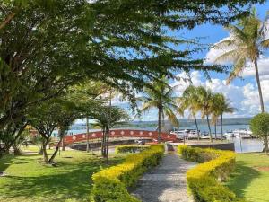 einen Gehweg in einem Park mit einer Brücke und Palmen in der Unterkunft Belo Flat Resort Lake Side Beira Lago in Brasilia