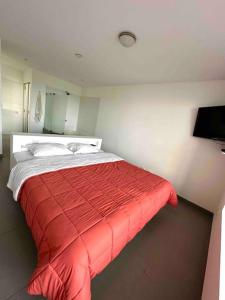 1 dormitorio con 1 cama con manta roja en Miramar Paracas® Depa frente al mar full equipo en Paracas