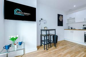 a kitchen with a table and a bar in a room at Stylish Media City Apartment, Sleeps 3, Darts Board, Smart TV, Tram Stop, Long Term Disc in Manchester