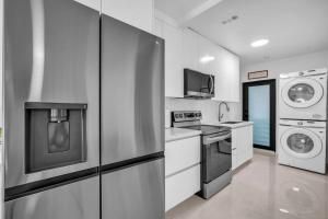 eine Küche mit einem Kühlschrank, einer Waschmaschine und einem Trockner in der Unterkunft Villa Roads Family Home 2 Beds 1 Bath in Miami