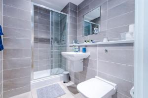 a bathroom with a shower and a toilet and a sink at Stylish Media City Apartment, Sleeps 3, Darts Board, Smart TV, Tram Stop, Long Term Disc in Manchester