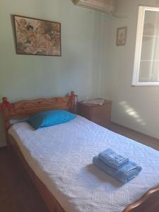 a bedroom with a bed with a blue towel on it at Ostriche House in Pentátion