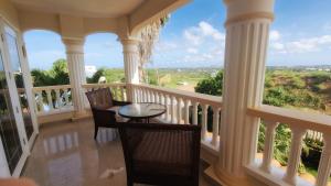 a balcony with a table and chairs and large windows at Reverie in Willemstad