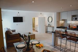 eine Küche und ein Wohnzimmer mit einem Tisch und einer Küche in der Unterkunft Alcazar Suites Deluxe in Salta