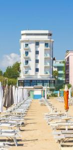 una fila di sedie e ombrelloni in spiaggia di Grand Meeting Hotel a Rimini