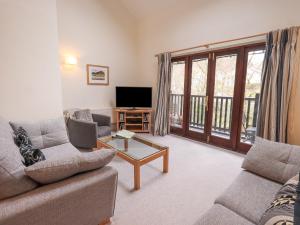 a living room with a couch and a tv at Beechside in Ambleside