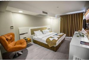 une chambre d'hôtel avec un lit et une chaise dans l'établissement GÜNTURPARK OTEL, à Beylerbeyi