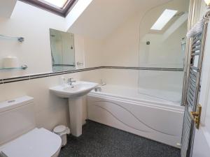 a bathroom with a sink and a tub and a toilet at Beechside in Ambleside +30 photos